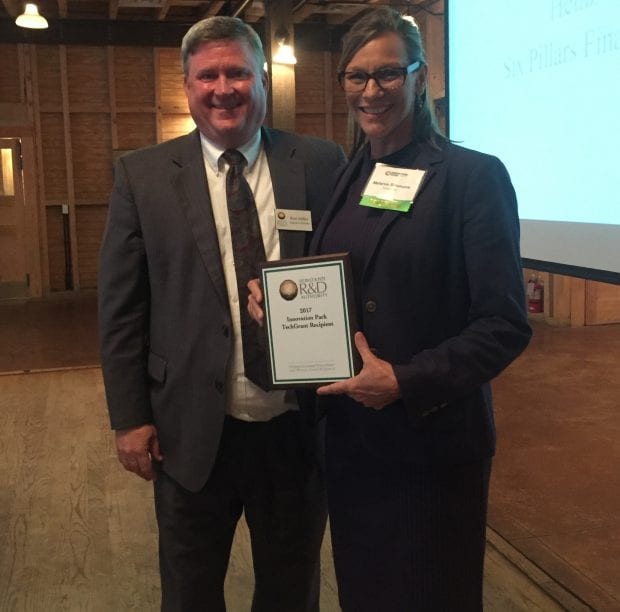 Leon County R&D Executive Director, Ron Miller (right) awarded President of KynderMed, Melanie Simmons (left) with a plaque at Innovation Park’s Elevator Pitch Night on May 17th.